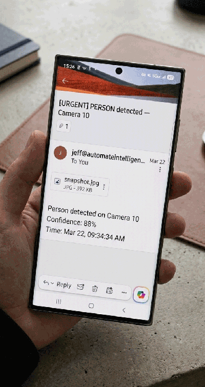Phone showing an urgent email alert from SecurityCamScanner: person detected on Camera 10 with 88% confidence, timestamp, and snapshot attachment