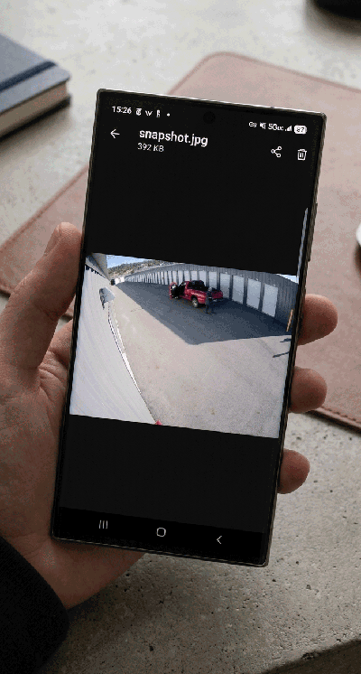 Phone displaying an attached camera snapshot showing a detection event at a self-storage facility